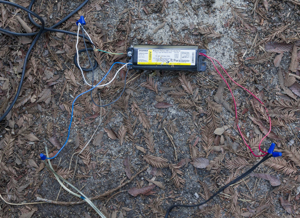fluorescent ballast and disorganized wiring lying on the ground