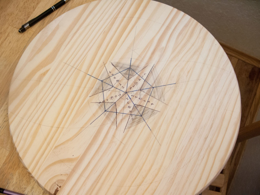 pentagon drawn in pencil on a circle of wood