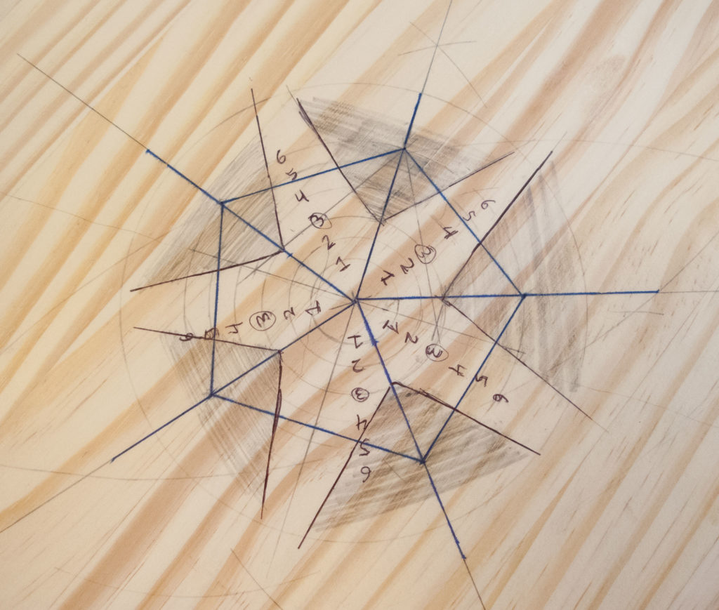 close-up of pentagon drawn in pencil on a circle of wood