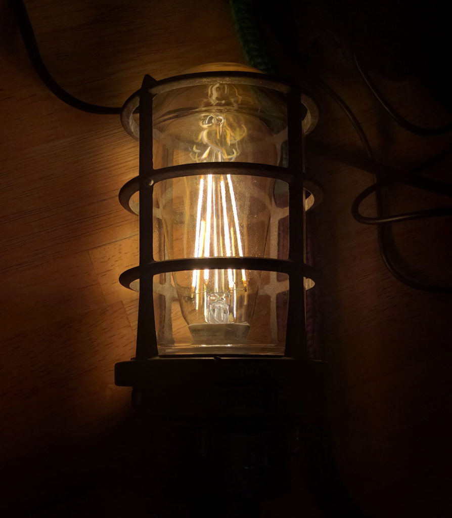 glowing LED filament light bulb inside a re-purposed outdoor light fixture