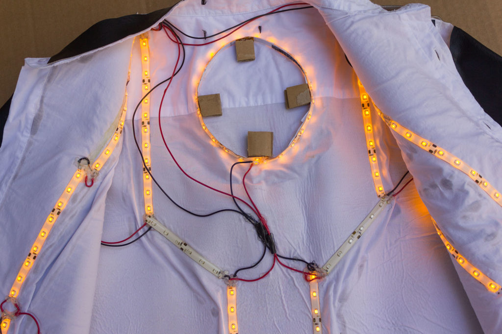 glowing amber LED strips laid out in a sci-fi pattern inside a white button-down shirt